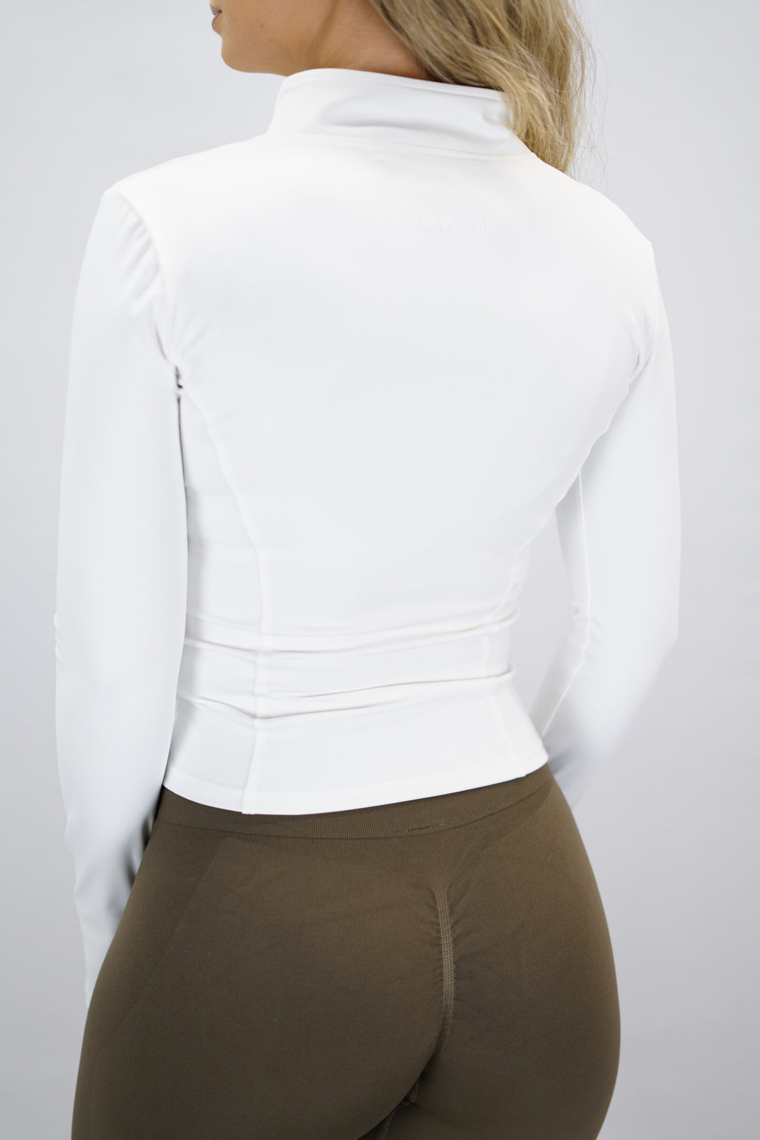 Vit Nalia Performance Long Sleeve Zipper Top - långärmad funktionströja med hel dragkedja, tumhål och Gymwear-logga i nacken