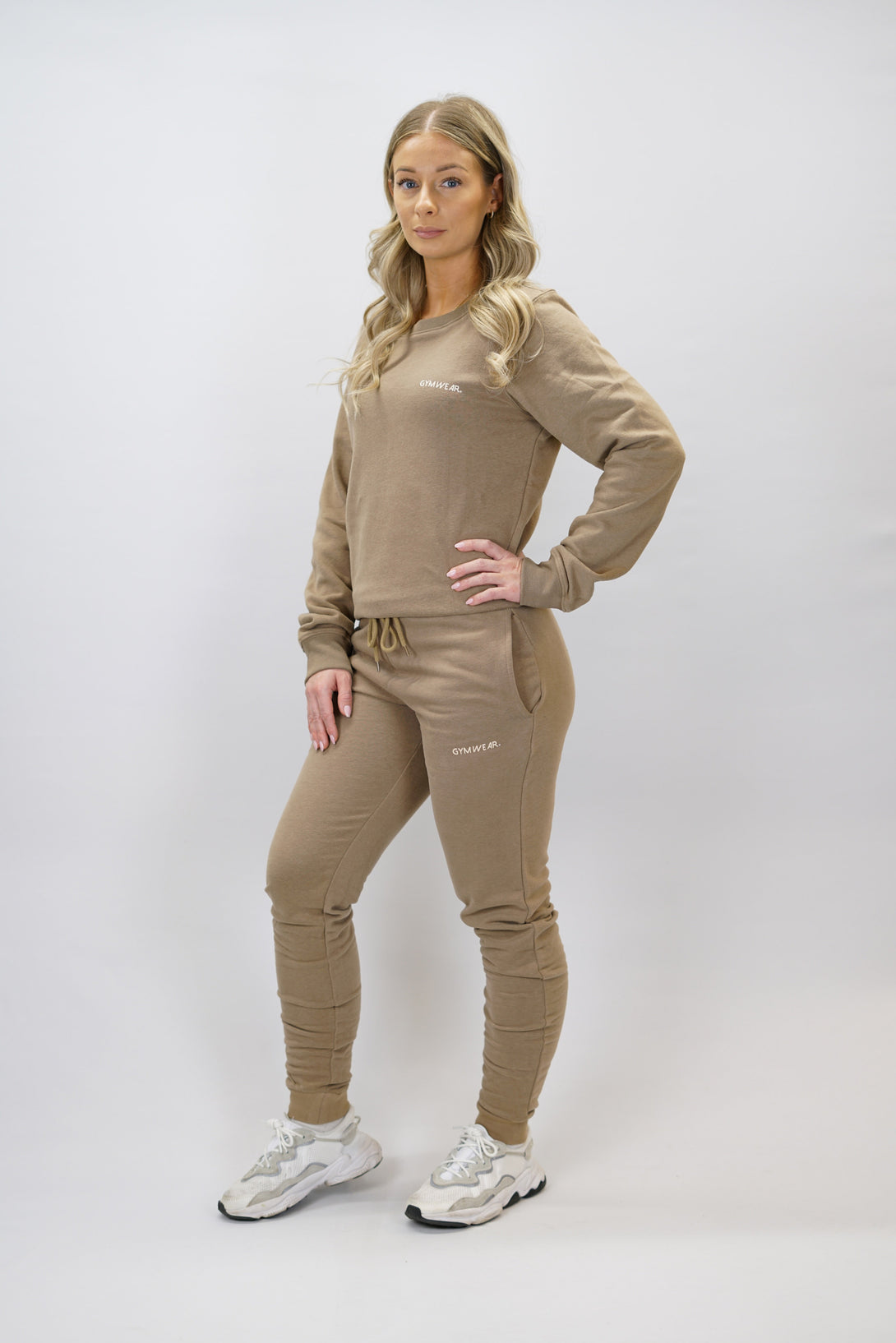Bekväma joggers i premium borstad bomull. JOGGER RAY har elastisk midja med justerbar dragsko, praktiska sidfickor och avsmalnande passform för en modern look. Perfekta för både träning och vardagsbruk. Brun färg med diskret Gymwear-logga på vänster lår.