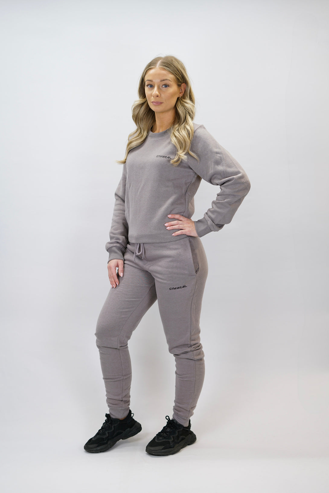 Bekväma joggers i premium borstad bomull. JOGGER RAY har elastisk midja med justerbar dragsko, praktiska sidfickor och avsmalnande passform för en modern look. Perfekta för både träning och vardagsbruk. Zink färg med diskret Gymwear-logga på vänster lår.