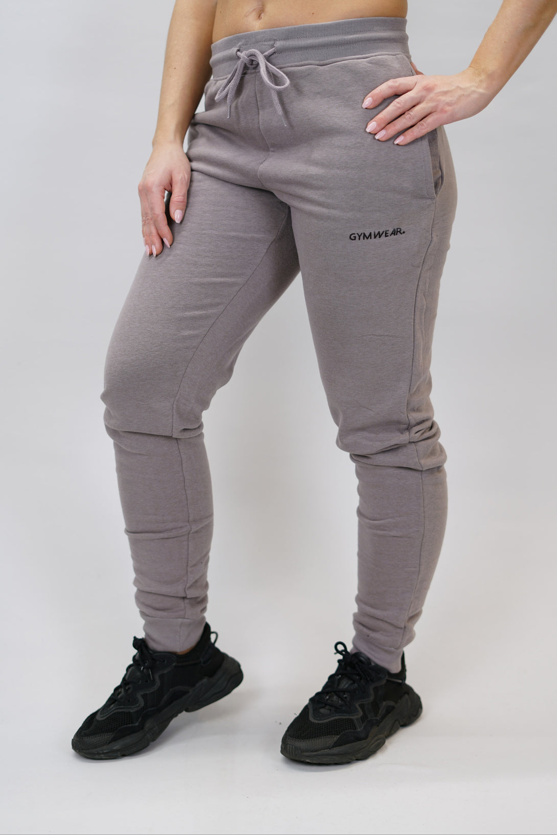 Bekväma joggers i premium borstad bomull. JOGGER RAY har elastisk midja med justerbar dragsko, praktiska sidfickor och avsmalnande passform för en modern look. Perfekta för både träning och vardagsbruk. Zink färg med diskret Gymwear-logga på vänster lår.
