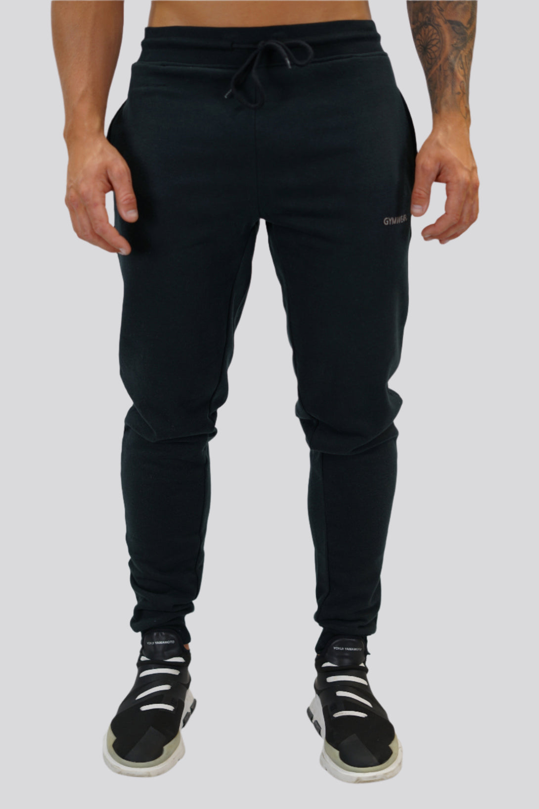 Bekväma JOGGER RAY i premium borstad bomull. Elastisk midja med dragsko, praktiska fickor och avsmalnande passform. Perfekt för träning och vardagsbruk. I svart med Gymwear  logga på vänster lår.