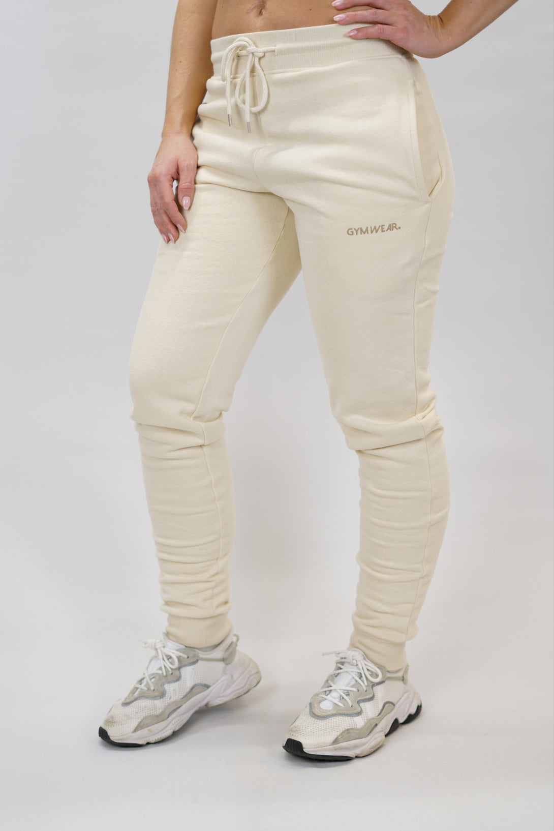 Bekväma JOGGER RAY i premium borstad bomull. Elastisk midja med dragsko, praktiska fickor och avsmalnande passform. Perfekt för träning och vardagsbruk. I färgen beige med Gymwear  logga på vänster lår.