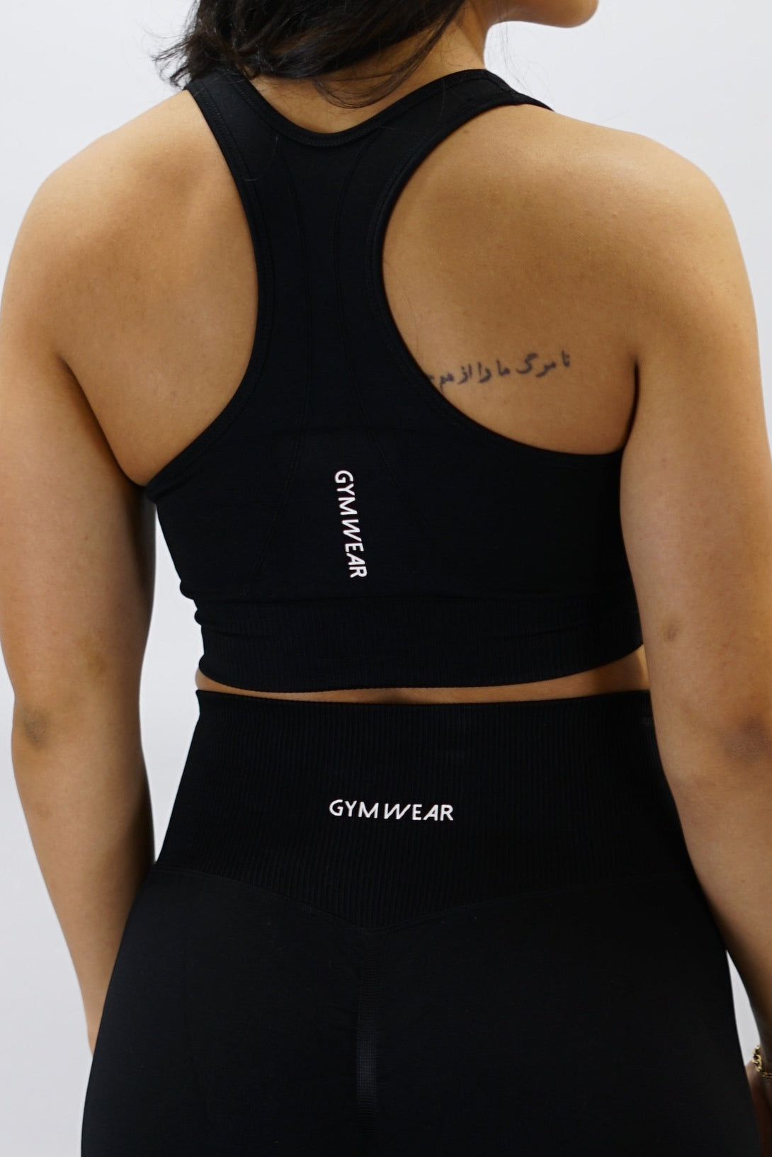 Svart Celia Bra - stabil och komfortabel sport-bh med G-symbol på vänster sida och lodrätt Gymwear-logga bak