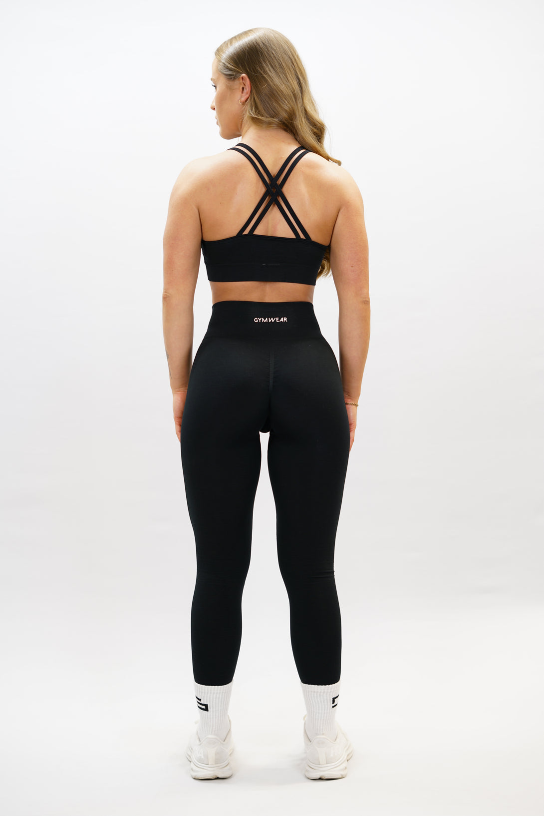 Svart Naima Premium Sport Bra - premium sport-bh med axelsnören och korsade band på ryggen, Gymwear-logga på framsidan