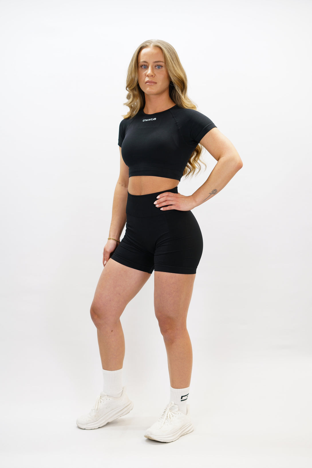 Svart Naima Short-Sleeve Cropped Top - cropped kortärmad träningströja med Gymwear-logga på framsidan