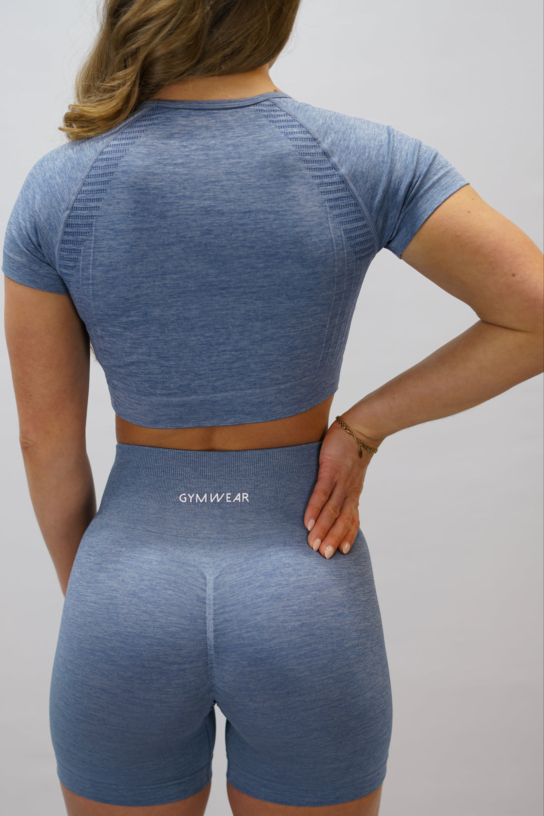 Blå Naima Short-Sleeve Cropped Top - cropped kortärmad träningströja med Gymwear-logga på framsidan