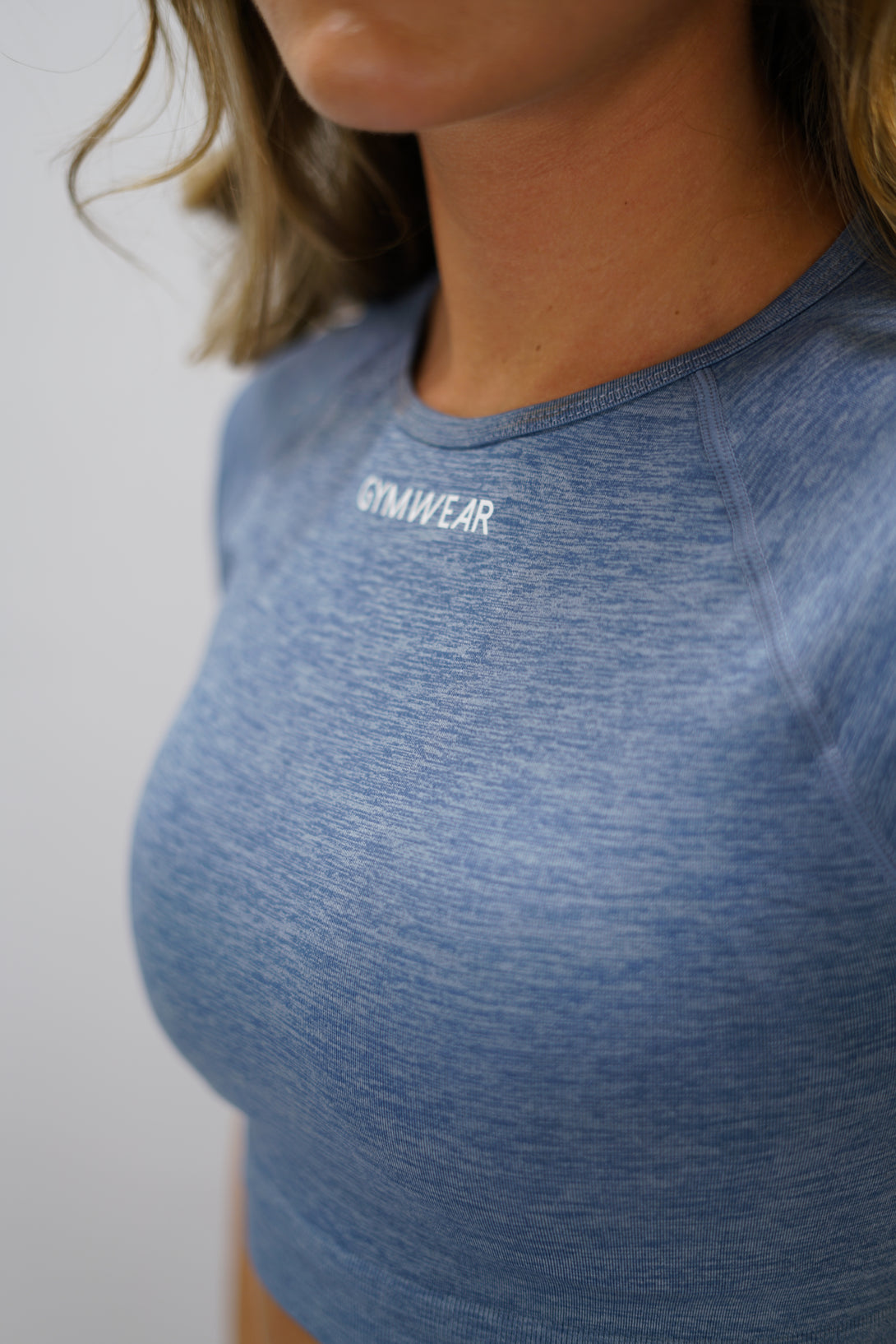 Blå Naima Short-Sleeve Cropped Top - cropped kortärmad träningströja med Gymwear-logga på framsidan